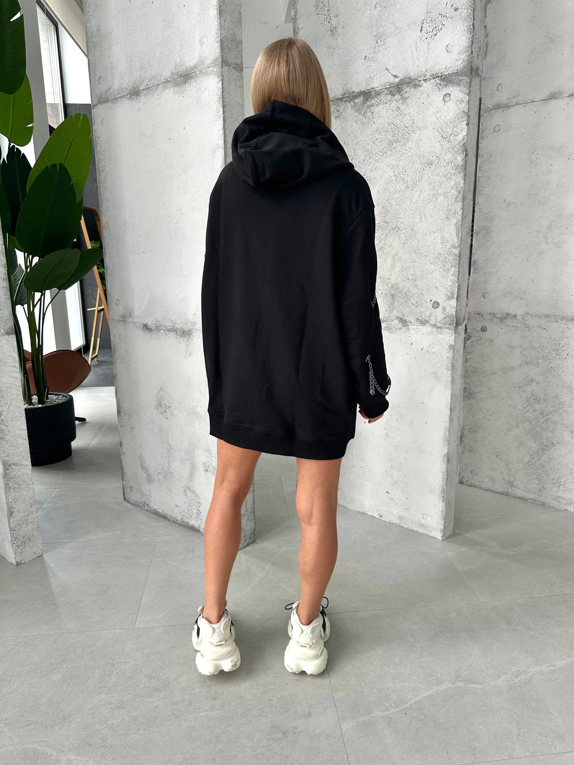 Oversized women’s black hoodie with front zipper and metal accents