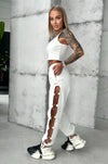 Women’s white joggers with bold cut-out leg design and metal ring accents