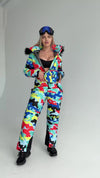Side view of multicolored ski jumpsuit with removable fur hood, waist-shaping fit, and insulated winter fabric