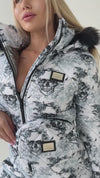Side view of women’s one piece snow suit showing fitted waist, bold skull pattern, and insulated winter fabric